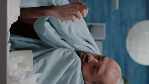 Vertical Video Close Up of Sick Man Looking at Tablet and Bottle with Pills
