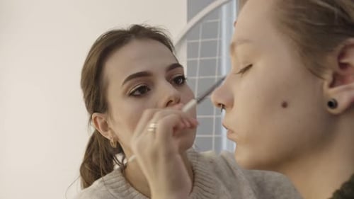 Woman Applying Makeup to a Woman's Face