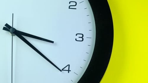 Clock Hands Sweep Against a Yellow Background