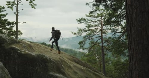 A Man is Climbing a Cliff