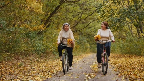 Happy Elderly Women Enjoy Cycling in Autumn Park