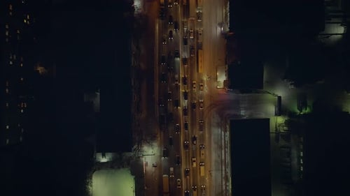 The Camera Gradually Floats on the Night Road with Slow Cars with Headlights On.