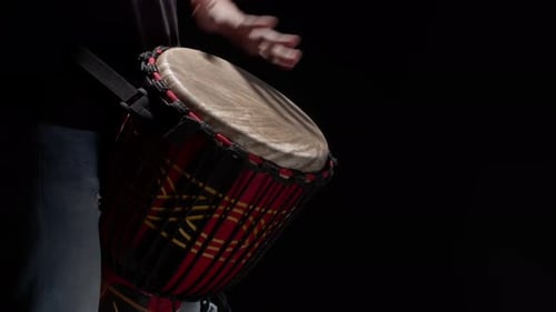 Schwarzer Mann spielt Trommel mit Händen Nahaufnahme im Studio