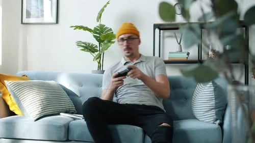 Man Playing Video Game on Couch in Living Room