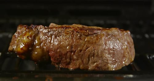 Juicy Steak Cooking on a Grill