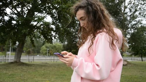 Young Adult Using Mobile Phone in the Park