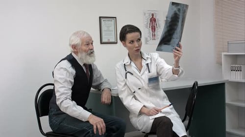 Doctor Explaining X-ray Results To Senior Patient.