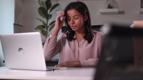 Woman Looking at Laptop Screen and Smiling Sitting at Table in Modern Office Spbi