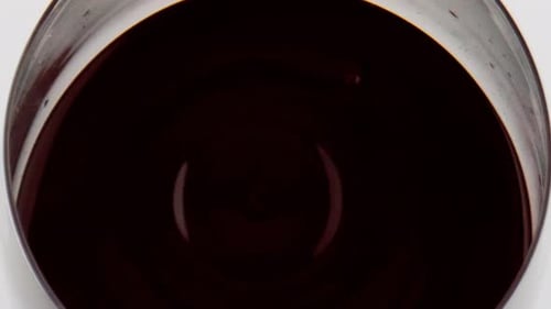 Nahaufnahme von herabfallendem Glas mit Rotweintropfen