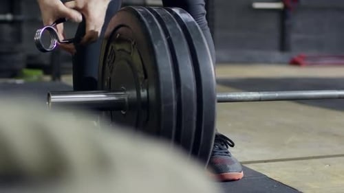 Female Athlete Preparing Barbell