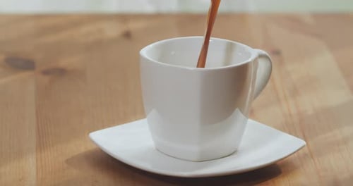 Black Coffee is Poured Into a Cup Top View