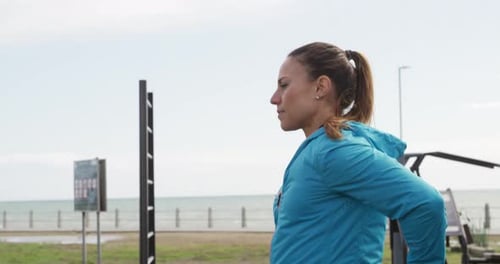 Sporty Caucasian woman exercising in an outdoor gym during daytime