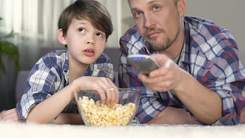 Father and Son Watch TV Eating Popcorn