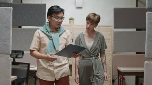 Two Multiethnic Colleagues Going along Office and Communicating