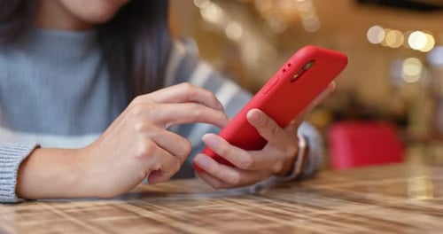 Woman use of mobile phone inside restaurant