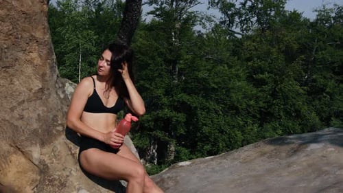 Young Woman Athlete Drinks Water From Plastic Bottles After Practice Exercises
