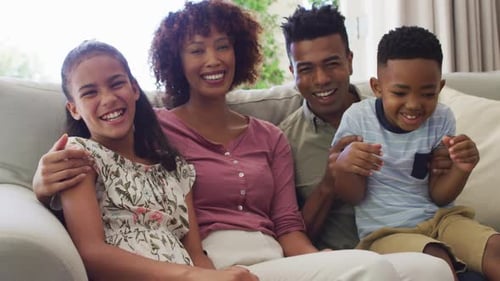 Smiling Family Together on Couch Indoors
