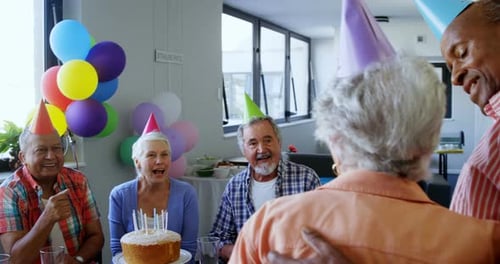 Senior Adults Celebrating Birthday with Cake and Balloons