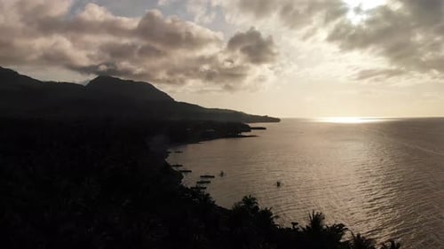 4k drone aerial over an exotic tropical island paradise in the Pacific Ocean at dusk and sun rays sh