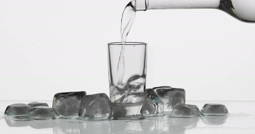 Clear Liquid Poured into Shot Glass with Ice