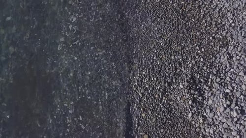Rocky sea and waves on transparent clear water aerial view. Rocks and stones in the coast seashore.