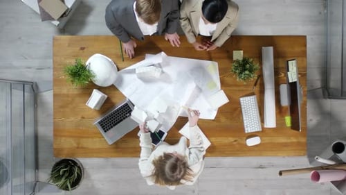 Architects Reviewing Plans Together in Office Environment