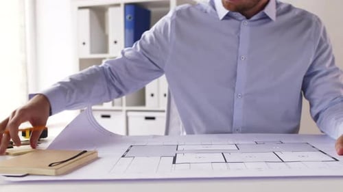 Architect with Blueprint Taking Notes at Office 27