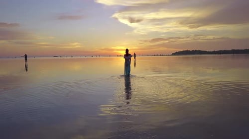 Junge Frau Silhouette Gehen im Meer bei schönem Sonnenuntergang Thailand
