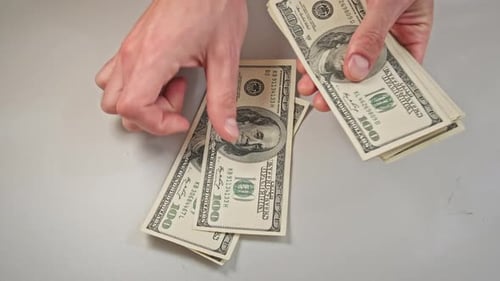 Hands Counting Stack of One Hundred Dollar Bills