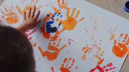 Child Making Colorful Handprint Art Project