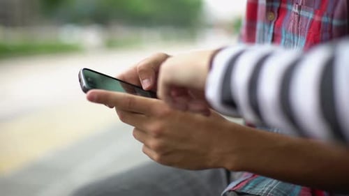 Young Adults Using Smartphone Together Outdoors