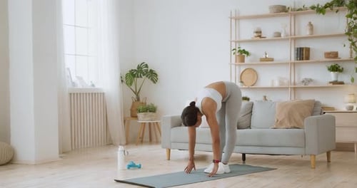 Woman Stretching on Yoga Mat Indoors