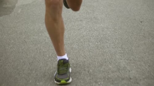 Runner's Legs in Motion on Pavement