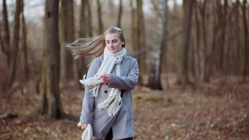 Portrait of Positive Woman Walking in Park in Autumn