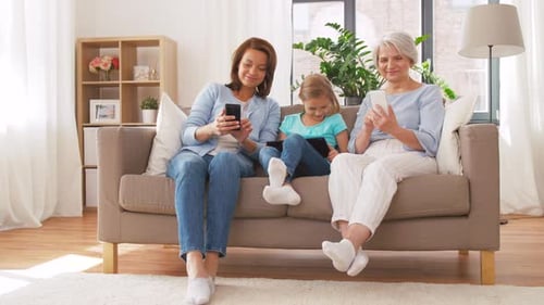 Three Generations on Couch Using Technology