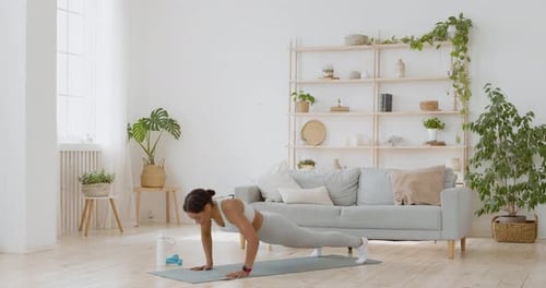 Woman Exercising on Yoga Mat at Home
