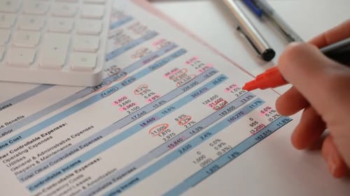 Nahaufnahme von Händen des Abschlussprüfers, die Notizen zum Finanzbericht machen