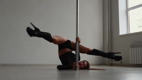 Flexible Woman Dancing on Pole in Studio