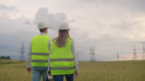 An Electrician in the Fields Near the Power Transmission Line