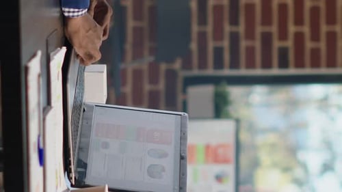 Man Reviews Data on Laptop in Modern Office