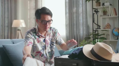 Man Packing Suitcase for Travel in Living Room