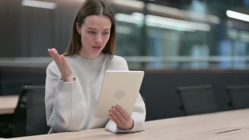 Young Woman Video Calling on Tablet in Office
