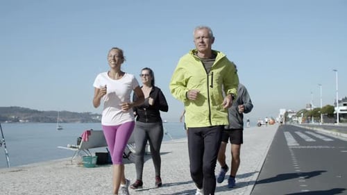 Active Senior Joggers Running on Promenade