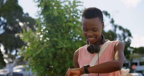 Woman Checks Smartwatch in Urban Green Environment