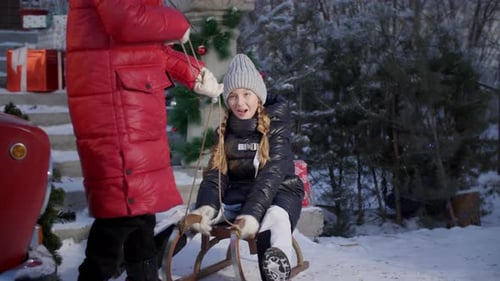 Girl on Sled Being Pulled in Winter Snow