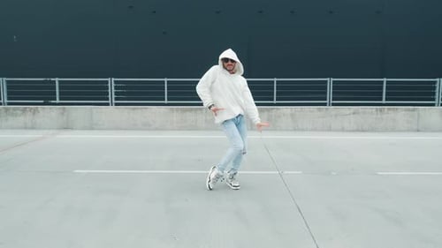Fashionable Dancer Man in Sportswear and with Glasses is Performing Outdoor Street Dancing Motion