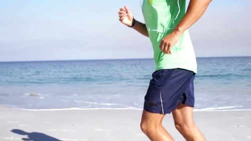 Fit man jogging on the beach