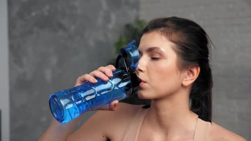 Woman Drinks Water from Reusable Bottle, Close Up