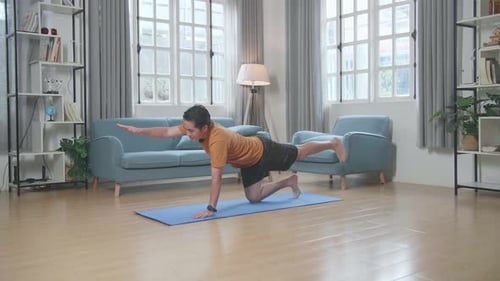 Asian Man Doing Yoga In Balancing Table Pose On Mat At Home