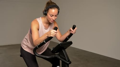 Athletic Lady Riding on the Stationary Bike